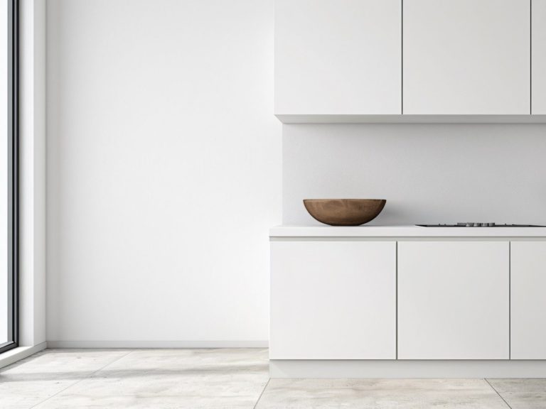 Moderne, minimalistische weiße Küche Moderne, minimalistische Küche mit weißen Schränken und einer Holzschale auf der Arbeitsfläche.