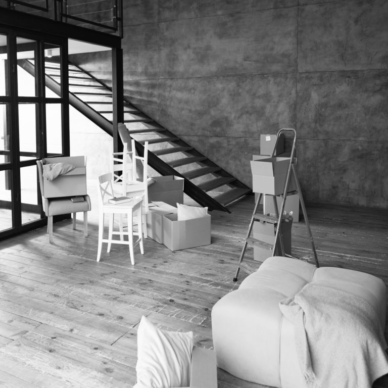 Renovierung in einem Raum mit Möbel Heller Raum mit Treppe, Leiter, Möbeln und Umzugskartons in neutralen Tönen.