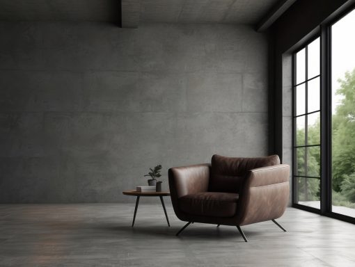 heller lichtdurchfluteter Raum Brauner Sessel neben einem Tisch vor großen Fenstern mit Blick ins Grüne.