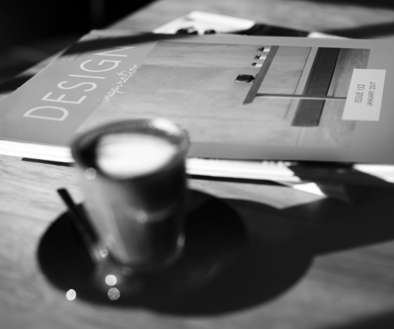 Ein Tasse Kaffee auf einem Tisch, daneben eine DESIGN-Zeitschrift.