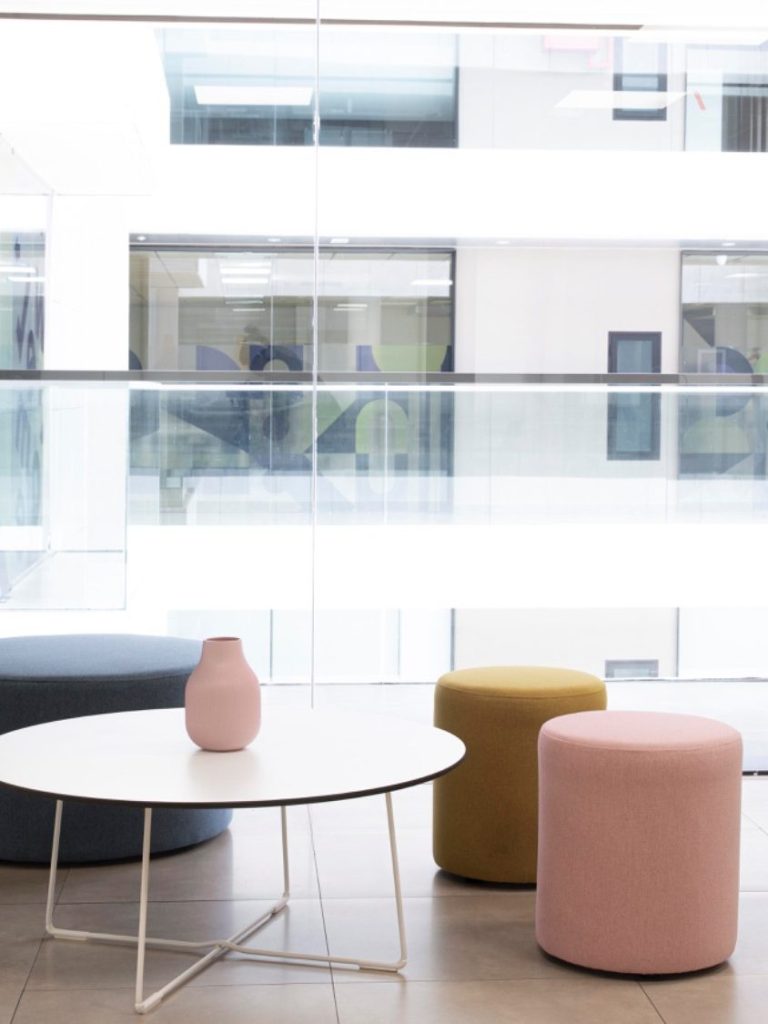 moderne Sitzgruppe Moderne Sitzmöbel und Vase in einem hellen, offenen Raum mit Glaswänden.
