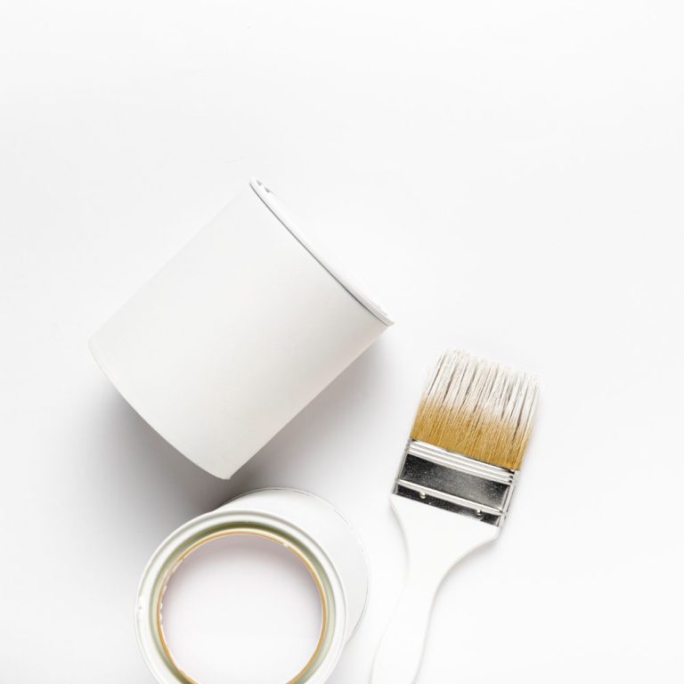 Weißer Farbtopf neben Pinsel und Malerband auf hellem Hintergrund.